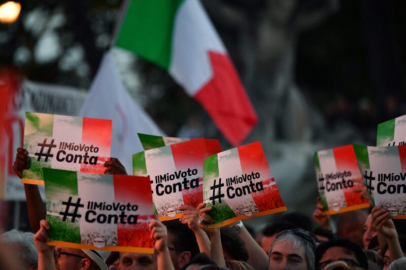 M5S supporters hold banner reading (My vote counts) during a meeting to celebrate the new Italy's gouvernment in  Rome, on June 2, 2018,  Giuseppe Conte was finally sworn in today afternoon at the head of an anti-establishment and eurosceptic government, ending months of uncertainty since elections in March. / AFP / Alberto PIZZOLI
