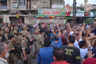 Lebanese army soldiers stand before anti-government protesters during a demonstration in Beddawi town on the outskirts of the northern Lebanese port city of Tripoli on October 26, 2019. Troops clashed with residents of the Beddawi area as they were trying to close a main road, according to the state-run National News Agency. A medical source in the area told AFP that at least four people were wounded by live fire and seven others in confrontations with the army.
 / AFP / Fathi AL-MASSRI
