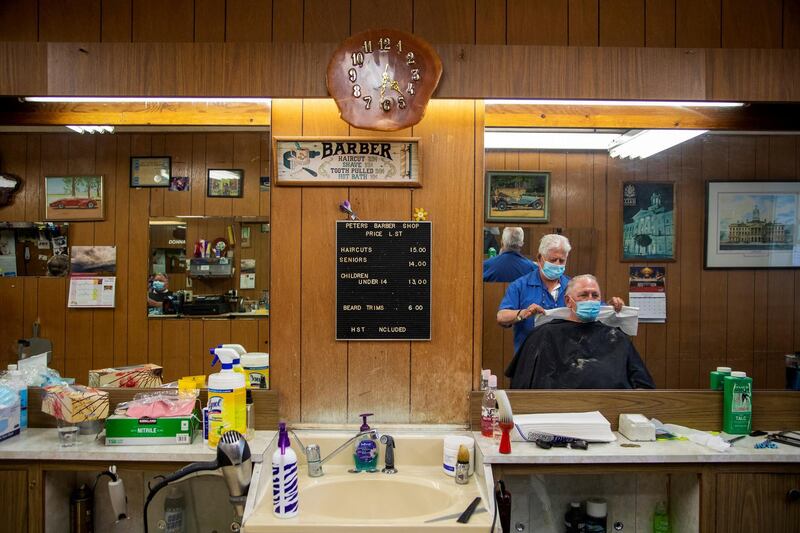 Peter Bosciglio cuts Joe Krywionek's hair at Peter's Barber shop as the provincial phase 2 reopening from the coronavirus disease restrictions begins outside of the Toronto area, in Cobourg, Ontario, Canada. Reuters