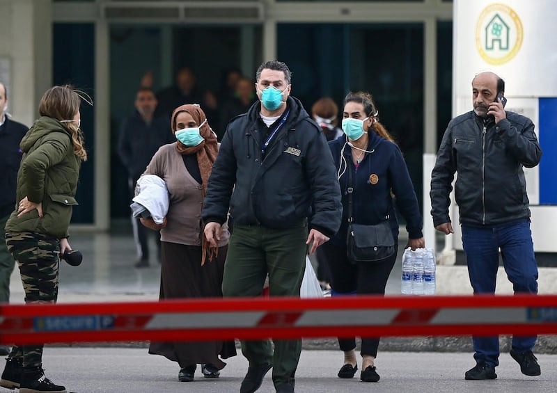 People wear face masks as they walk outside of the Rafik Hariri University Hospital where a woman is treated for coronavirus, the first case in Beirut, Lebanon.  EPA