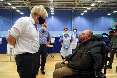 Britain's Prime Minister Boris Johnson speaks with a man waiting to receive an Oxford-AstraZeneca COVID-19 vaccine, during his visit at a vaccination centre at Cwmbran Stadium in Cwmbran, south Wales, Britain February 17, 2021. Geoff Caddick/Pool via REUTERS