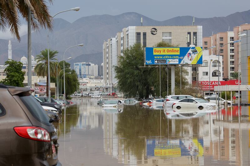 Cars partially submerged on a street in Gubrah, Muscat.