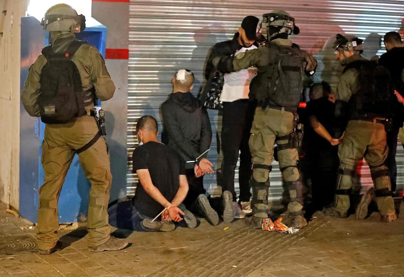 Israeli forces detain a group of Arab-Israelis in the mixed Jewish-Arab city of Lod on May 13, 2021, during clashes between Israeli far-right extremists and Arab-Israelis. / AFP / Ahmad GHARABLI
