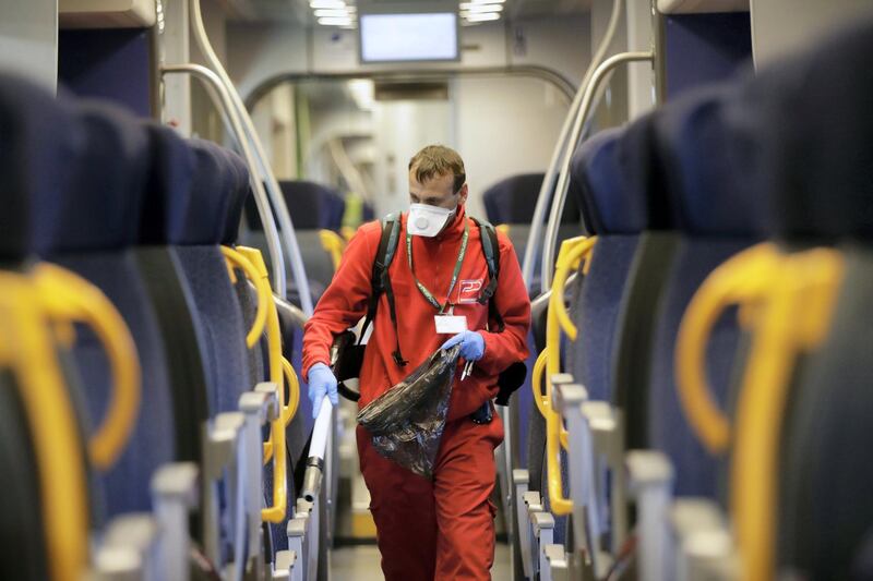 A cleaner sanitizes a wagon on a regional train, at the Garibaldi train station in Milan, Italy, Friday, Feb. 28, 2020. Authorities are taking new measures to sanitize trains and public transportation after the COVID-19 virus outbreak. (AP Photo/Luca Bruno)