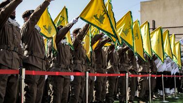 Hezbollah fighters raise the group's flags during the funeral of two of its members who were killed in an Israeli strike on April 17. AFP