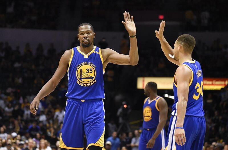 Golden State Warriors forward Kevin Durant, left, high-fives Stephen Curry during a pre-season game. Denis Poroy / AP Photo / October 19, 2016