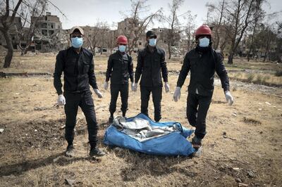 A team of firefighters in central Raqqa carry a body bag out of the city. David Pratt for The National