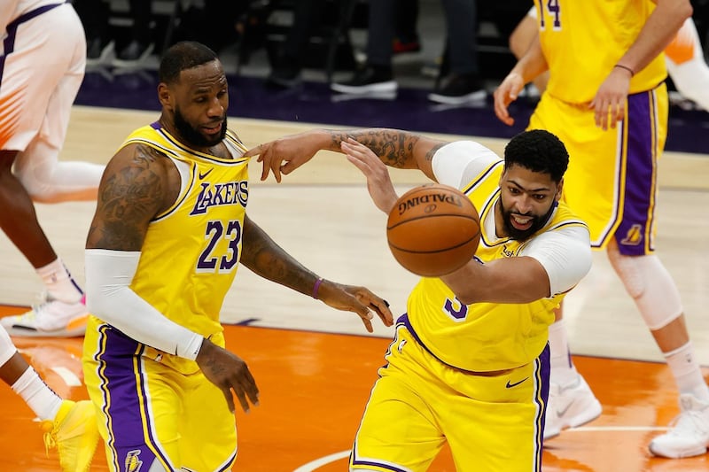 LeBron James and Anthony Davis of the Los Angeles Lakers attempt to control a loose ball. AFP