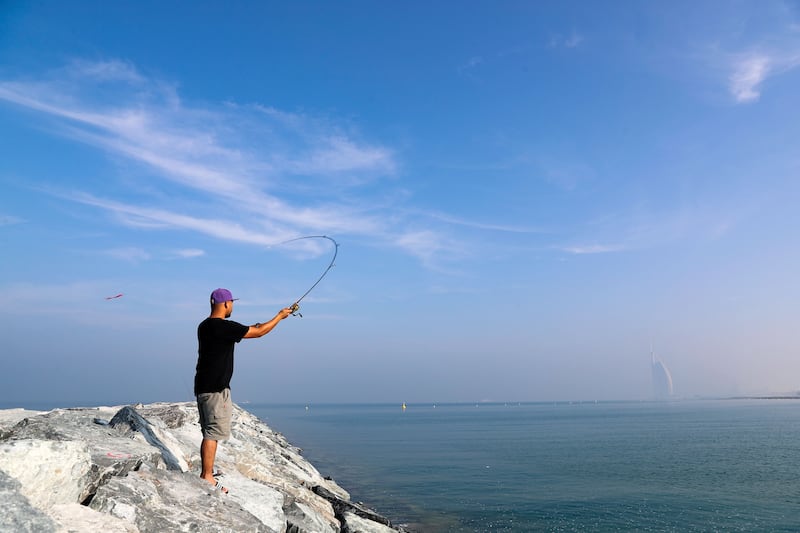 Fishing on a hazy New Year's Day morning overlooking the Burj al Arab, Dubai. Chris Whiteoak/The National