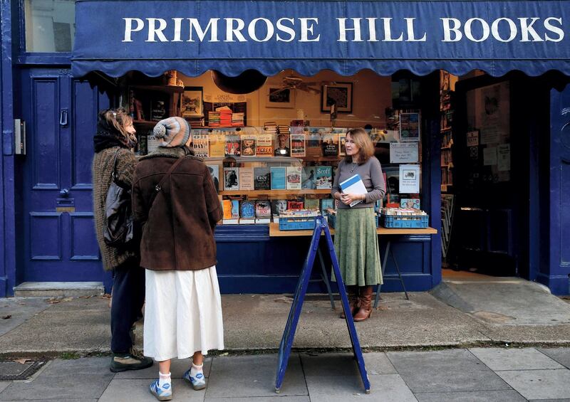 Jessica Graham (R), owner of independent book shop Primrose Hill Books, talks to members of the public outside her shop in west London on November 6, 2020. - Some 250 small independent bookshops have joined forces to compete with online giants such as Amazon during the second coronavirus lockdown in England. Unlike other countries such as Belgium, sales of books are not deemed to be essential, despite studies indicating more people turned to reading in the first lockdown earlier this year, and outlets have had to close their doors until December 2. Bookshop.org, which was launched in the United States earlier this year, is now available in Britain and in just a few days has generated £60,000 for the retailers taking part in its "click and collect" service. (Photo by Hollie Adams / AFP)