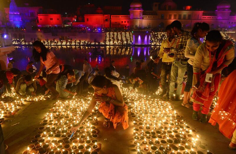 People lighting earthen lamps on the banks of the River Sarayu on the eve of Diwali. AFP