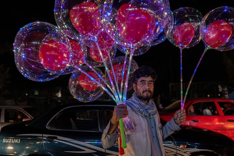 A man selling balloons at night in Kabul a month since the start of Taliban rule. All photos by Stefanie Glinski
