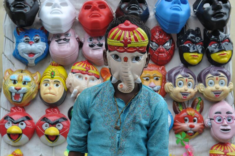 An Indian boy wears a mask of Hindu deity Ganesh in Hyderabad. Noah Seelam / AFP Photo