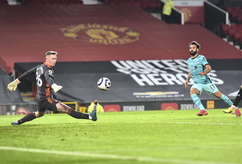 MANCHESTER, ENGLAND - MAY 13: Mohamed Salah of Liverpool scores their side's fourth goal past Dean Henderson of Manchester United during the Premier League match between Manchester United and Liverpool at Old Trafford on May 13, 2021 in Manchester, England. Sporting stadiums around the UK remain under strict restrictions due to the Coronavirus Pandemic as Government social distancing laws prohibit fans inside venues resulting in games being played behind closed doors. (Photo by Peter Powell - Pool/Getty Images)