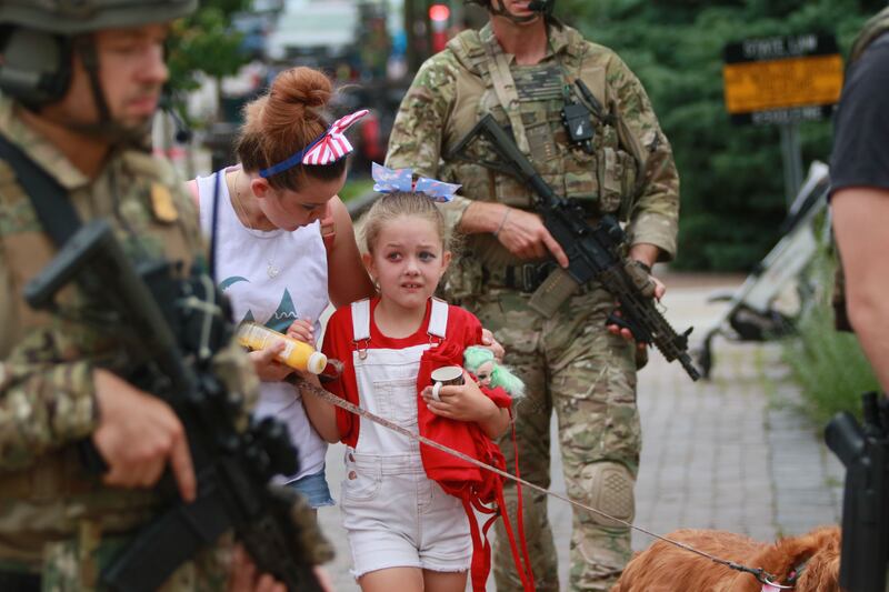 Law enforcement officers escort a family away from the scene. AFP