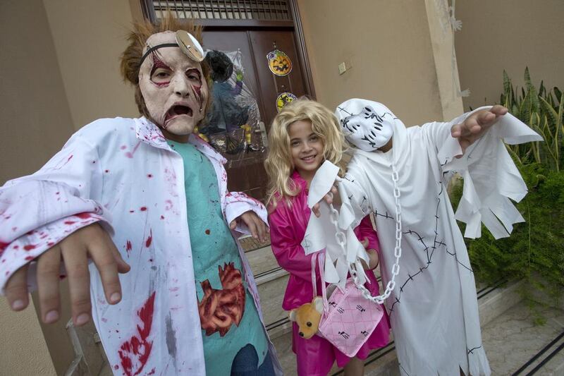 Little horrors: Zaid, Yasmin and Adam show off the Halloween costumes they hope will scare neighbours into parting with plenty of treats when the trio go out trick or treating. Jaime Puebla / The National