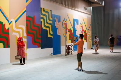 Visitors posing with an adapted recreation of a mural from the first Asilah Moussem Festival of the Arts in 1978. Courtesy Alserkal Arts Foundation