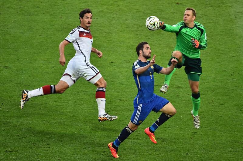 Germany's goalkeeper Manuel Neuer, right, and Argentina's forward Higuain compete for the ball. Gabriel Nouys / AFP