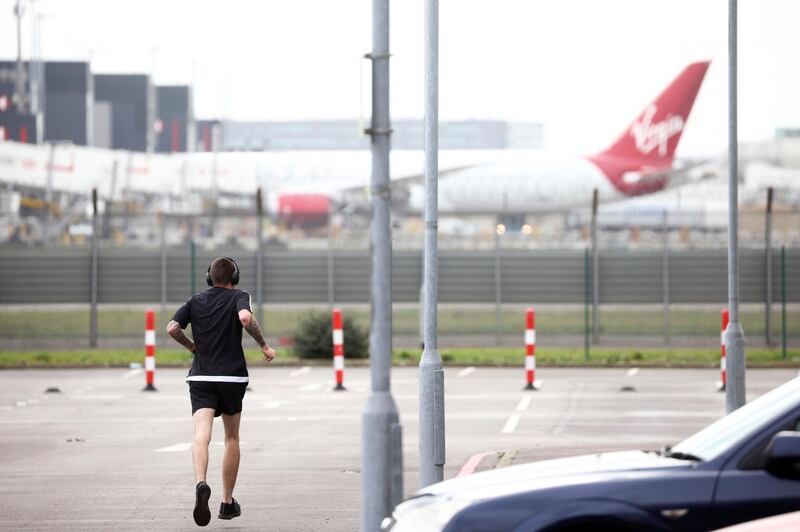 A man exercises under supervision of security in the car park of Renaissance London Heathrow Hotel at Heathrow Airport.