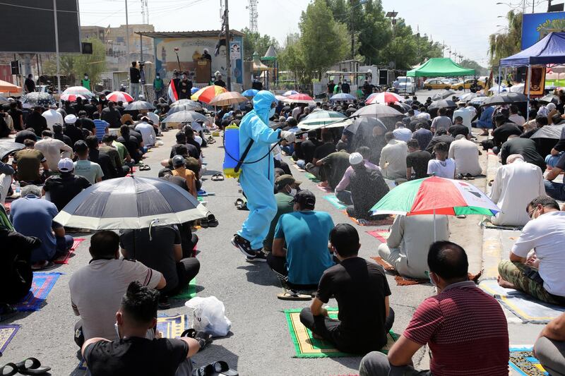 A medical personnel sprays disinfectant as Iraqi worshipers perform their Friday Prayers in Sadr City, Iraq.  EPA