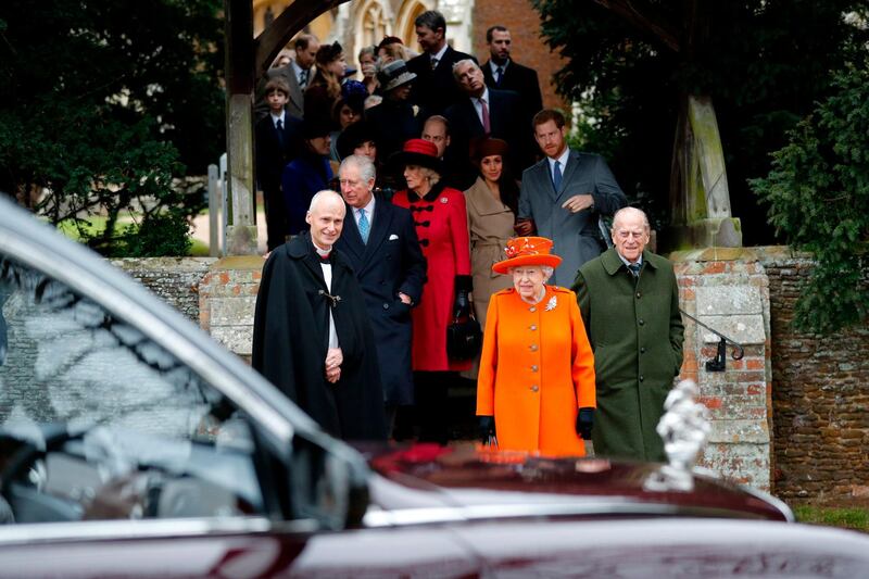 Britain's Queen Elizabeth and Britain's Prince Philip, Duke of Edinburgh, right, lead out other members of the family with Reverend Canon Jonathan Riviere, left, as they leave after attending the Royal Family's traditional Christmas Day church service. Adrian Dennis / AFP photo