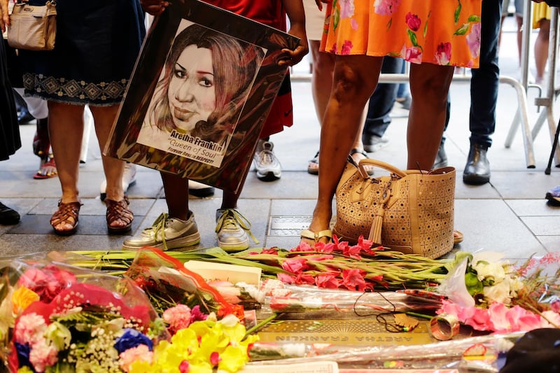 People gather at a makeshift memorial at the nameplate for singer Aretha Franklin outside the Apollo Theatre in New York. AP Photo