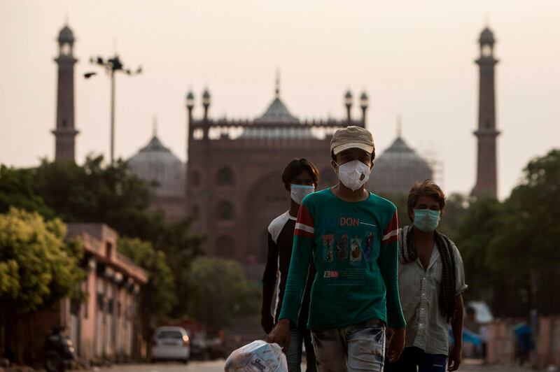 People walk along a street outside the Jama Masjid after the government eased a nationwide lockdown imposed as a preventive measure against the COVID-19 coronavirus in the old quarters of New Delhi.  AFP