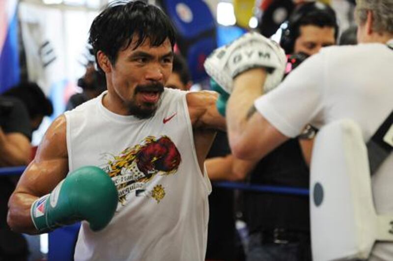 Manny Pacquiao works out with trainer Freddie Roach (R) at a media day training session at Wildcard Boxing Club in Hollywood, California, October 26, 2011.   Pacquiao will defend his World Boxing Organization (WBO) welterweight title against Juan Manuel M‡rquez in Las Vegas on November 12.    AFP PHOTO / Robyn Beck