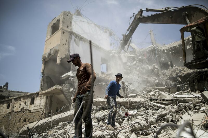 Palestinians work on the remains of a building destroyed during the 2014 war between Israel and Hamas-led militants, in Gaza city in April 2016. AFP