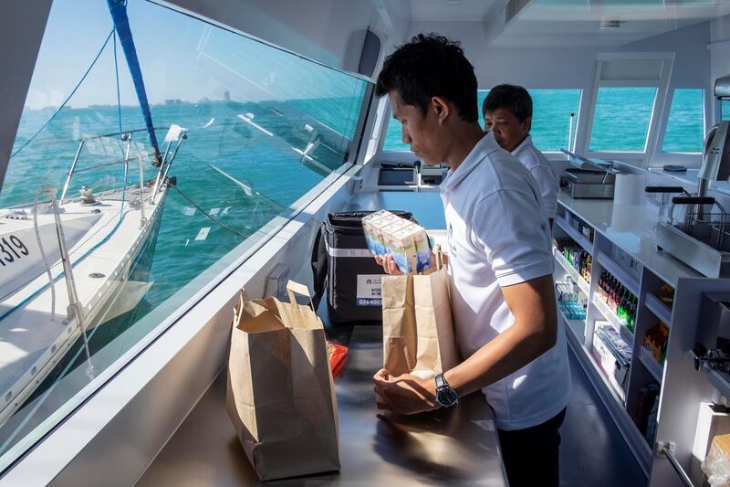 DUBAI, UNITED ARAB EMIRATES. 12 DECEMBER 2018. Trying out the new floating Carrefour mini market off the coast of Dubai. Dubai resident Marie Byrne takes her yacht out to try the new Carrefour floating shop. The floating shop has an assortment of items from icecream to fresh salads and dry goods. An employee packes an order into delivery bags. (Photo: Antonie Robertson/The National) Journalist: Nicke Webster. Section: National.