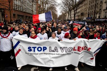 Protesters hold a banner reading 'Stop the Violence' as thousands of 'Foulards Rouges' (Red Scarfs) demonstrators march in support of the government policy in Paris, France. EPA