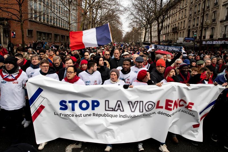 epa07325421 Protesters hold a banner reading 'Stop the Violence' as thousands of 'Foulards Rouges' (Red Scarfs) demonstrators march in support of the government policy in Paris, France, 27 January 2019. This march is organized to support the government and denunciate the so-called 'gilets jaunes' (yellow vests), a grassroots protest movement with supporters from a wide span of the political spectrum, that originally started with protest across the nation in late 2018 against high fuel prices. The movement in the meantime also protests the French government's tax reforms, the increasing costs of living and some even call for the resignation of French President Emmanuel Macron.  EPA/ETIENNE LAURENT