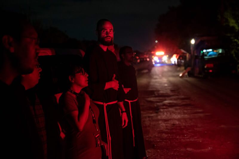 Local priests from the San Antonio Archdiocese stand near the scene. AFP