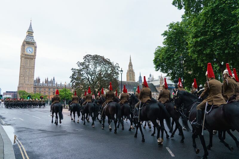 Troops of the Household Cavalry make their way through Parliament Square. PA