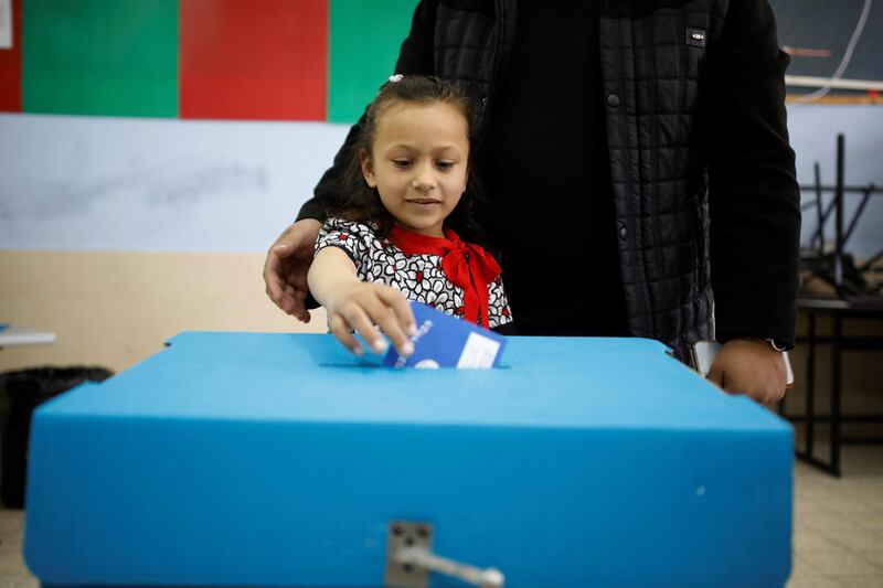 A girl casts her fathers ballot as Israelis began voting in a parliamentary election. Reuters