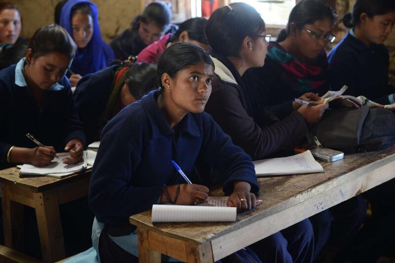 Nepalese schoolgirl Susmita Kami, centre, 16, at school in Simikot, the headquarters of Humla district, on November 6, 2014. Three years ago, the teenager escaped from a forced marriage and begged her parents not to send her back as she wanted a better life. Prakash Methema/AFP Photo