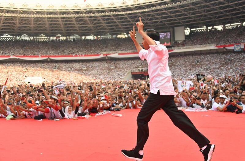 Incumbent Indonesian President Joko Widodo arrives onstage for an election rally on the final day of campaigning in Jakarta on April 13, 2019. AFP