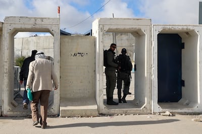 Israeli soldiers stand guard as Palestinians arrive at a checkpoint in Qalandia, in the occupied West Bank. AFP
