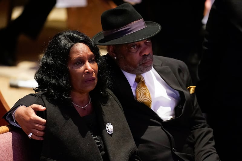 Ms Wells is comforted by her husband at the funeral service. AP