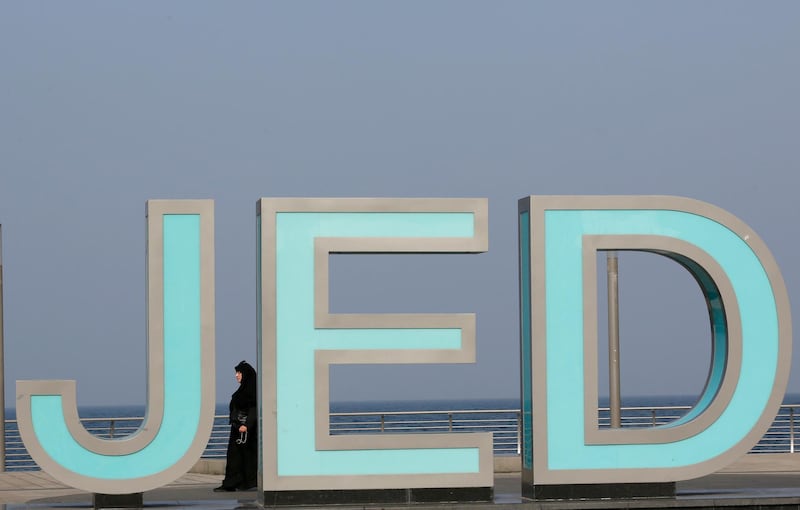A visitor of the new Jeddah Corniche walks behind an object with the name of the city, in Jeddah, Saudi Arabia. AP Photo