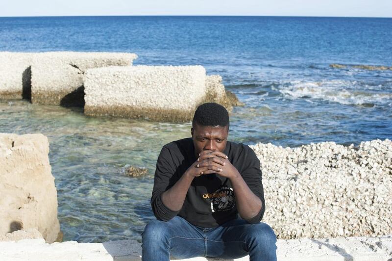 In this photo taken on Friday, November. 11, 2016, Marc Samie sits by the sea in Pachino, Sicily, waiting for news of his pregnant wife Louise, who he last saw standing on a beach in Libya. tears rolling down her face as traffickers forced him into a rubber dinghy at gunpoint. Salvatore Cavalli / AP 