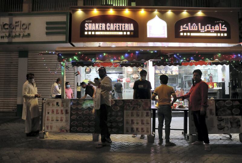 DUBAI, UNITED ARAB EMIRATES , April 27 – 2020 :- People buying food from one of the restaurant in Al Ras area in Deira Dubai. Authorities ease the restriction for the residents after almost a month long locked down of Al Ras district. (Pawan Singh / The National) For News/Standalone/Online/Instagram