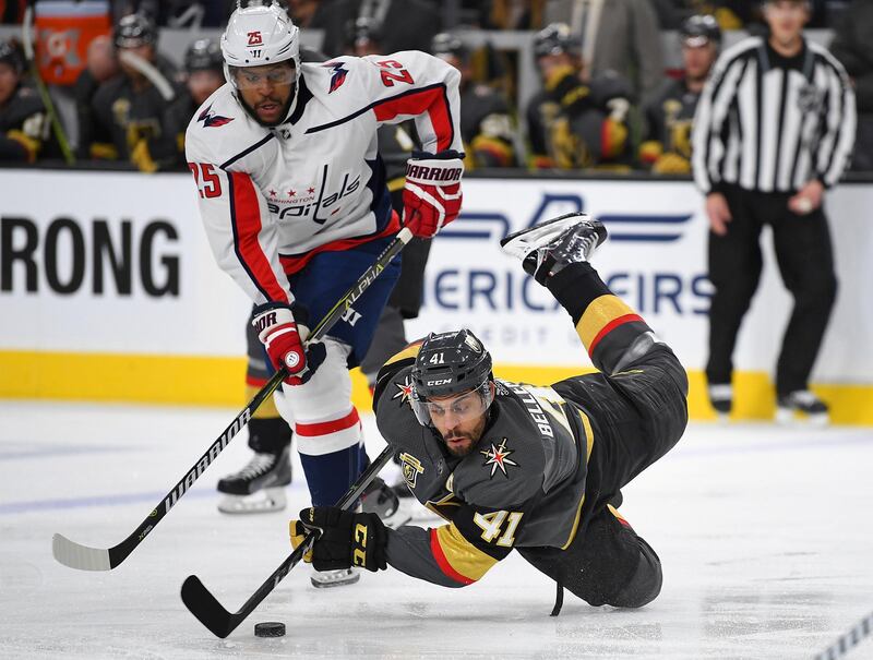 Vegas Golden Knights left wing Pierre-Edouard Bellemare falls to the ice while controlling the puck away from Washington Capitals right wing Devante Smith-Pelly during the first period of play at T-Mobile Arena. Stephen R. Sylvanie / USA TODAY