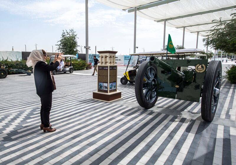A woman takes a snapshot of the French cannon at Al Wasl Plaza