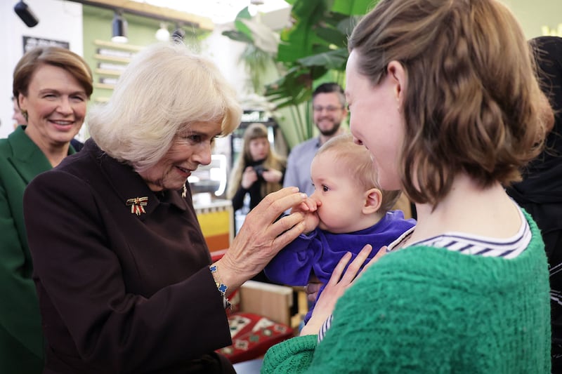 Queen Consort Camilla met a baby during a stop at the Refugio Cafe in Berlin. AFP