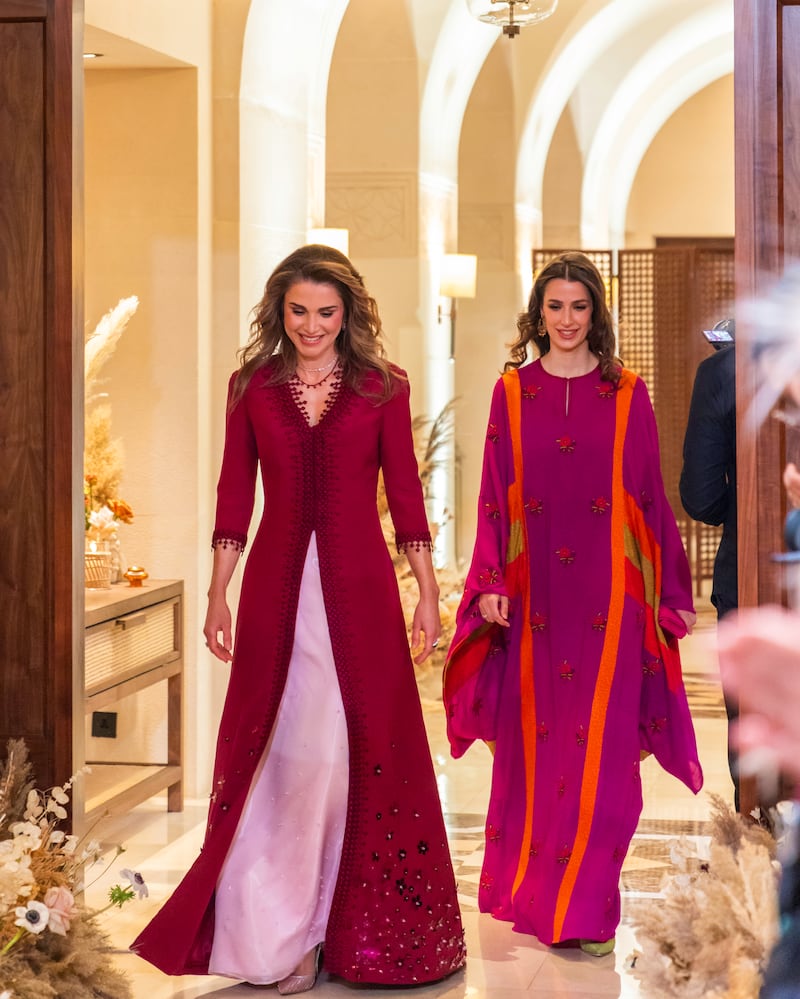 Queen Rania, left, sports a floor-length pink and maroon dress during the party, while Rajwa Al Saif - Crown Prince Hussein bin Abdullah's fiancee - wears a kaftan-style gown in a similar shade