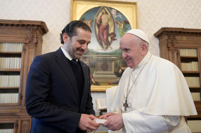 This photo taken and handout on April 22, 2021 by The Vatican Media shows Pope Francis and Lebanon's prime minister-designate Saad Hariri exchanging gifts during a private audience in The Vatican. RESTRICTED TO EDITORIAL USE - MANDATORY CREDIT "AFP PHOTO /VATICAN MEDIA / HANDOUT " - NO MARKETING - NO ADVERTISING CAMPAIGNS - DISTRIBUTED AS A SERVICE TO CLIENTS
 / AFP / VATICAN MEDIA / Handout / RESTRICTED TO EDITORIAL USE - MANDATORY CREDIT "AFP PHOTO /VATICAN MEDIA / HANDOUT " - NO MARKETING - NO ADVERTISING CAMPAIGNS - DISTRIBUTED AS A SERVICE TO CLIENTS
