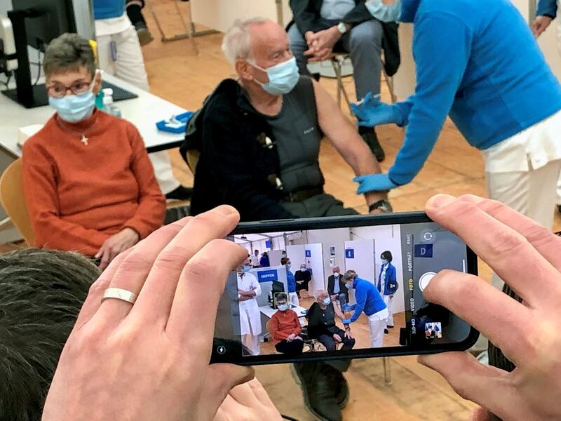 Mr. Stuessi receives a  vaccine as his wife sits beside at the vaccination reference center at the Epidemiology, Biostatistics and Prevention Institute in Zurich, Switzerland. Reuters