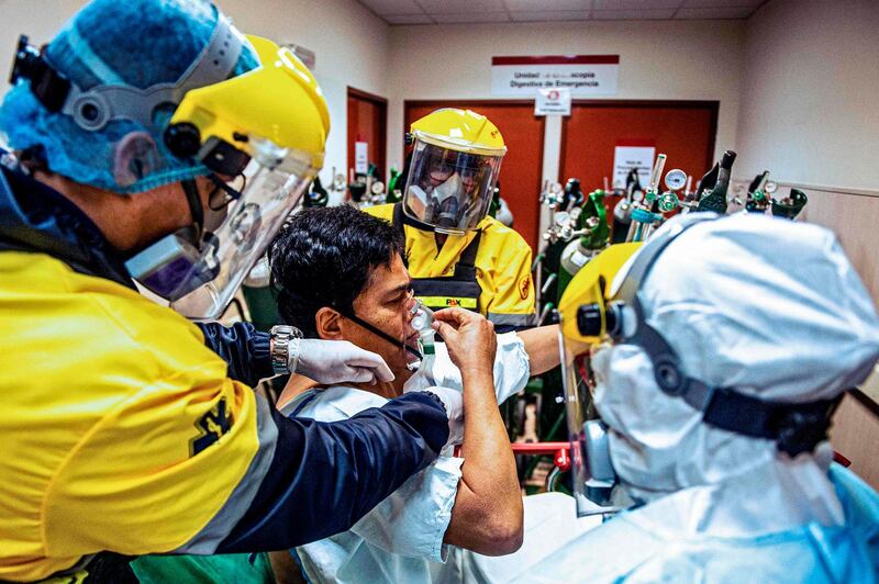 Juan Carlos Lara, 59, a patient with Covid-19, is surrounded by health workers in the Intensive Care Unit of the Rebagliati Hospital, in Lima, Peru. AFP