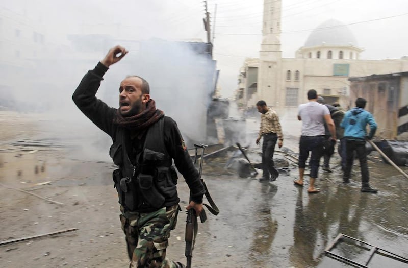 A Free Syrian Army fighter walks away as residents try to put out a fire after what activists said was shelling from forces loyal to president Bashar Al Assad on a fuel vendor in Aleppo. Molhem Barakat / Reuters





